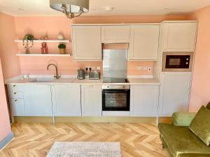 a kitchen with white cabinets and a sink at The Hudson in Market Weighton