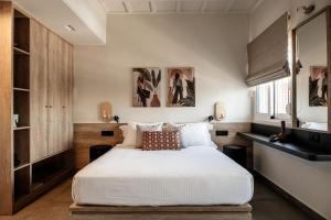 a bedroom with a large bed with white sheets at Vinnies Homes in Heraklio Town