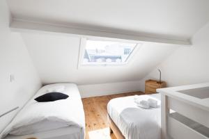 a white room with two beds and a window at Les Vigies by Cocoonr in Saint Malo