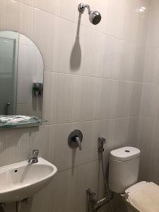 Kirei Hotel في Bonthain: حمام مع حوض ومرحاض ومرآة