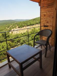 einen Stuhl und einen Tisch auf einem Balkon mit Aussicht in der Unterkunft Ajloun Forest Reserve in Gerasa