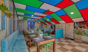 restauracja z kolorowym sufitem, stołami i krzesłami w obiekcie Treebo Trend Roshan House w mieście McLeod Ganj