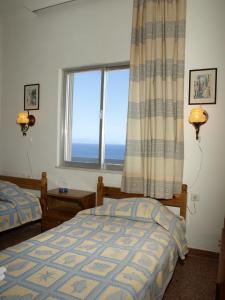 a bedroom with two beds and a large window at Villas Michalis in Chorafakia