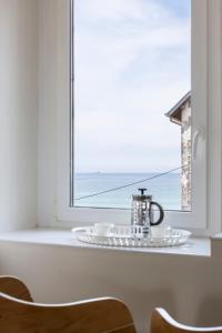 - une table avec une plaque de cuisson et une bouilloire devant une fenêtre dans l'établissement Les Vigies by Cocoonr, à Saint-Malo