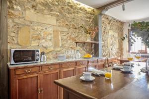a kitchen with a table and a stone wall at Casona los Cautivos in Oreña