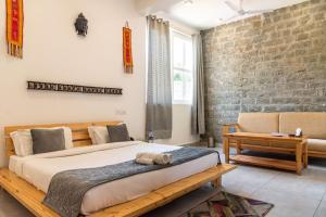 a bedroom with a bed and a brick wall at ilaka Homes in Bīr