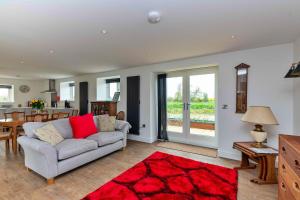 a living room with a couch and a red rug at Finest Retreats - The Warren in Stamford