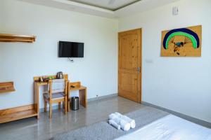 ilaka Homes في بير: غرفة نوم مع سرير ومكتب مع قوس قزح على الحائط