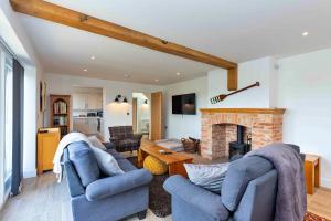 sala de estar con 2 sofás azules y chimenea en Finest Retreats - The Holt, en Stamford