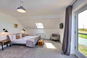 a bedroom with a bed and a large window at Finest Retreats - The Holt in Stamford