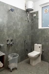 a bathroom with a toilet and a shower at ilaka Homes in Bīr