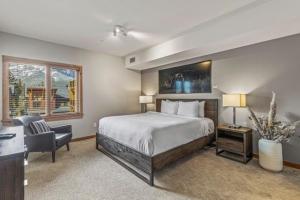 a bedroom with a bed and a desk and a chair at White Spruce Condo by Gordon Property Management in Canmore