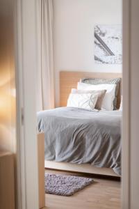 a bedroom with a bed with gray sheets and pillows at Rosfjord Strandhotel in Lyngdal