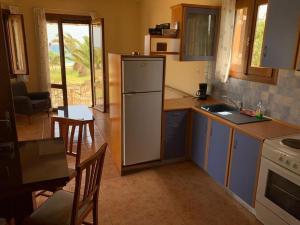 eine Küche mit Kühlschrank, Tisch und Stühlen in der Unterkunft Olga Studio Kouremenos in Palekastro