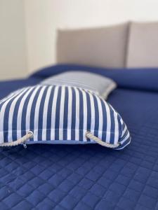 een kussen op een bed met een blauw en wit bij Appartamento Dipinto di blu- Vista Mare! in Nettuno