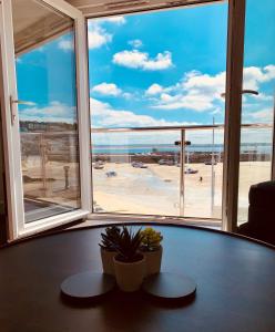 a table in a room with a view of a beach at Beach House Apartment 1 - St. Ives harbour front apartment with stunning views in St Ives
