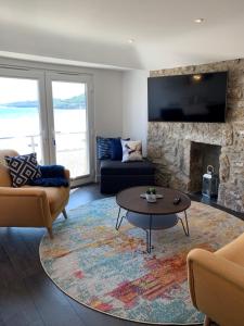a living room with a couch and a fireplace at Beach House Apartment 1 - St. Ives harbour front apartment with stunning views in St Ives