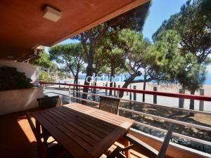 een houten tafel en stoelen op een balkon met bomen bij TAMARIUS 1-4 in Platja  d'Aro
