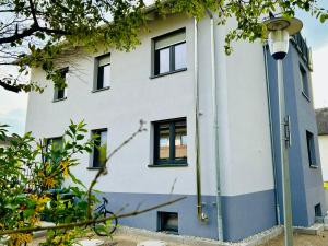 ein weißes Gebäude mit schwarzen Fenstern und einem Straßenlicht in der Unterkunft Ruheoase - Premium Suite in Karlsruhe