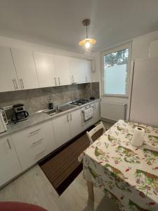 a kitchen with white cabinets and a table and a window at Apartament la Nicole ultracentral Bld Roman bloc 39 in Roman