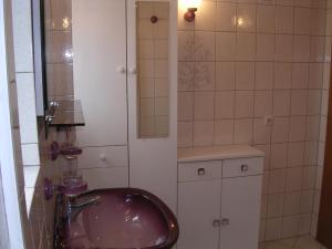 ein Bad mit einem Waschbecken und einem Spiegel in der Unterkunft Location Vacances Des 4 Vents in Girmont-Val-dʼAjol