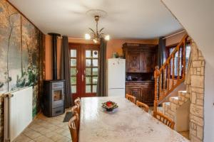 eine Küche mit einem Tisch und einem Kühlschrank in der Unterkunft Location Vacances Des 4 Vents in Girmont-Val-dʼAjol