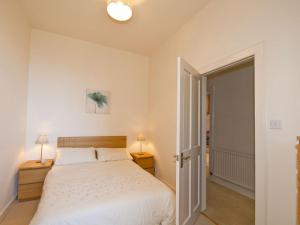a bedroom with a bed and two lamps and a door at Seabreeze in North Berwick
