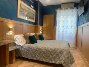 1 dormitorio con 1 cama con paredes azules en B&B Acasadibarbara en Roma