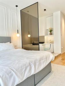 1 dormitorio con 1 cama blanca grande y espejo grande en Bulevard57 en Belgrado