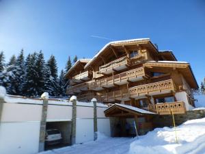 un gran edificio de madera con nieve delante en Appartement Les Saisies, 5 pièces, 8 personnes - FR-1-594-70 en Hauteluce