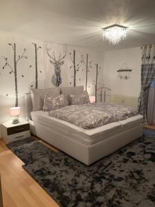 a white bed in a room with trees on the wall at Ferienresidenz Am Hauchen in Reit im Winkl