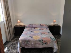 1 dormitorio con 1 cama con 2 lámparas en 2 mesas en Casa Rural Los Chapines en Vallehermoso
