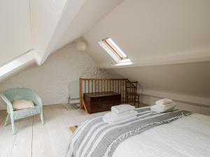 a attic room with a bed and a chair at 1 Hetfield Cottages in Bishops Castle