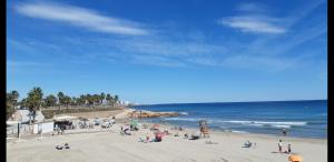 um grupo de pessoas numa praia perto do oceano em Casa Millie em Playa Flamenca