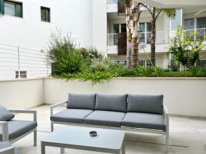 a couch and a coffee table in front of a building at Vilu Suite Centro in Polignano a Mare