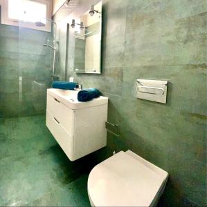een badkamer met een toilet, een wastafel en een spiegel bij La Galería in Calera