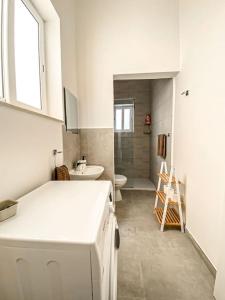 a white bathroom with a sink and a toilet at Unique two bedrooms apartment 6 in Il-Gżira