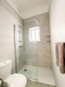 a white bathroom with a shower and a toilet at Unique two bedrooms apartment 6 in Il-Gżira