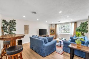 a living room with two blue chairs and a table at La Niña Nokomis Beach & Venice Island Fenced In Yard in Nokomis