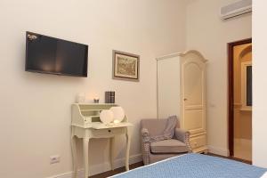 una camera con letto, scrivania e TV a parete di Daplace - Arena House a Roma Altre 37 foto