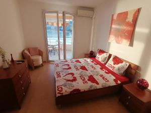 ブドヴァにあるLuxury Apartment Astelmnのベッドと椅子と窓のある寝室