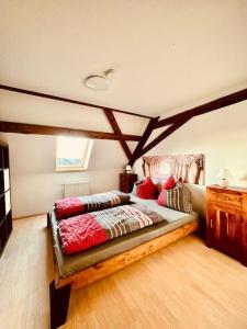 1 dormitorio con 1 cama en una habitación con suelo de madera en stilvolle Dachgeschoss-Wohnung in Top-Lage, en Großröhrsdorf