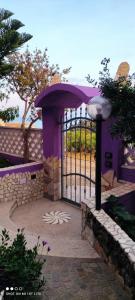 una puerta púrpura con una flor blanca delante de ella en Casa Purple, en Cala Gonone