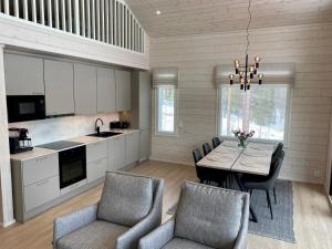 eine Küche und ein Esszimmer mit einem Tisch und Stühlen in der Unterkunft Villa Iiris - New Holiday Home in Äkäslompolo