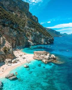 una spiaggia sul fianco di una scogliera di Sa Dommu de Kerciu vista mare IUN R0018 a Baunei