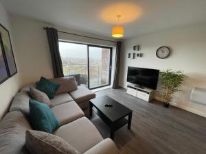 a living room with a couch and a tv at Balcony Marina Apartment With City Skyline Views in Manchester