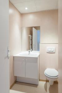 y baño con lavabo blanco y aseo. en City Résidence Marseille, en Marsella