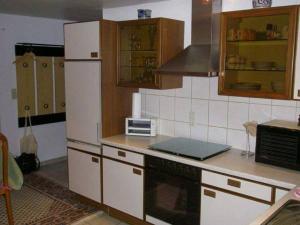 eine Küche mit einem weißen Kühlschrank und einer Mikrowelle in der Unterkunft Ferienwohnung Meier in Kippenheim