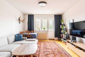 a living room with a couch and a flat screen tv at Quite room in apartement in Oslo