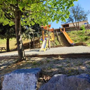 a playground with a slide in a park at Maison de 3 chambres avec piscine partagee jardin et wifi a Salavas in Salavas